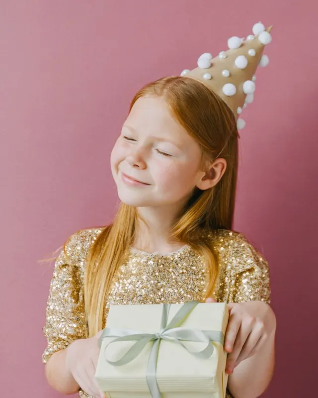 Girl in a gold dress holding a present